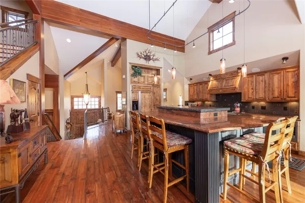 a dining hall with stainless steel appliances granite countertop a stove and a wooden floors