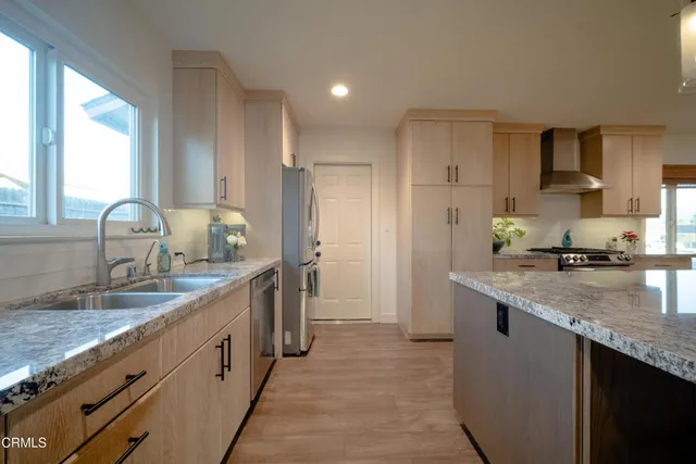 a kitchen with stainless steel appliances granite countertop a sink stove and refrigerator