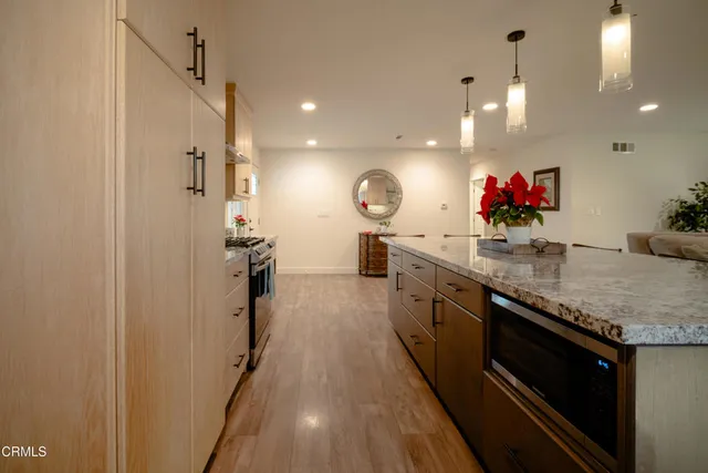 a kitchen with granite countertop a sink stainless steel appliances and cabinets