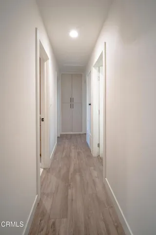 a view of a hallway with wooden floor