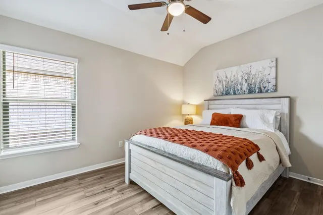 a bedroom with a bed and wooden floor