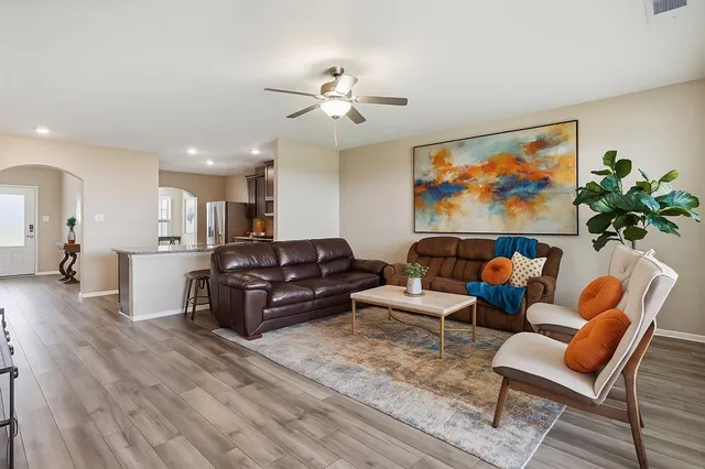 a living room with furniture a ceiling fan and a rug