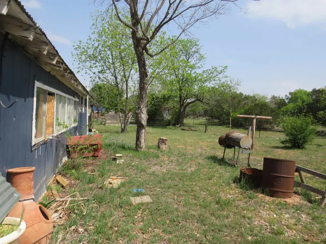 a backyard of a house with table and chairs