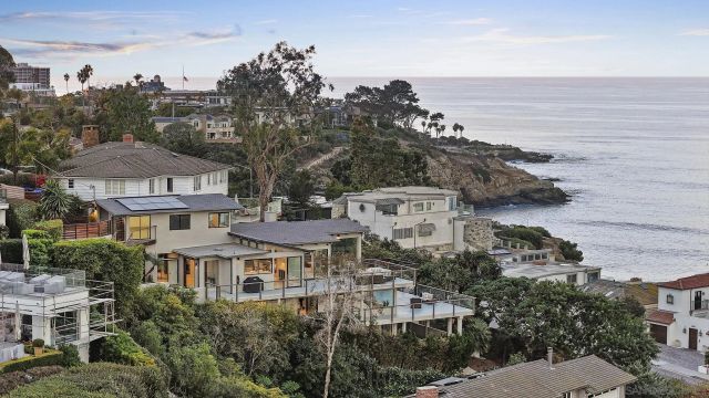 a front view of a house with a yard and ocean view