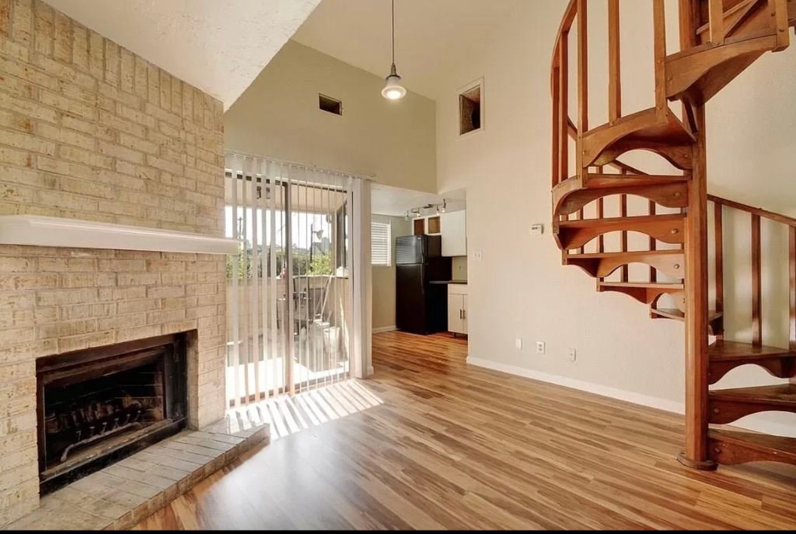a view of an entryway with wooden floor and a fireplace