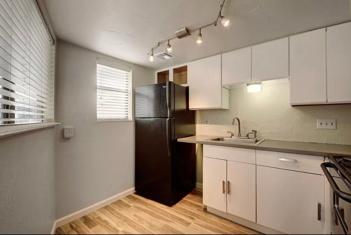 2500 Burleson Road, Unit 317 Austin, TX 78741 - Photo 4 of 12 a kitchen with a refrigerator and cabinets