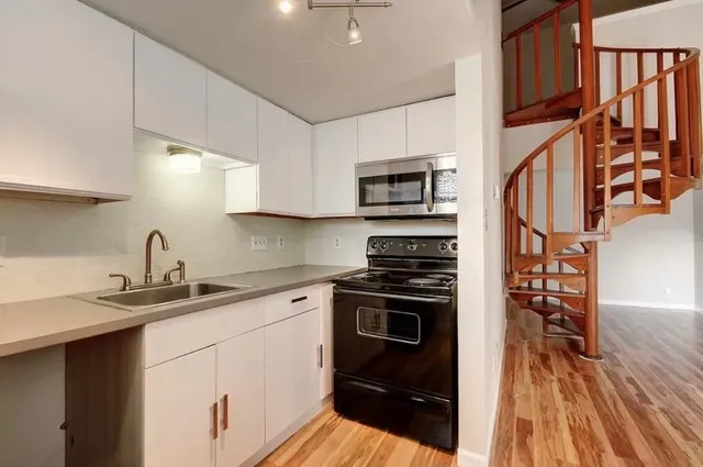 a kitchen with stainless steel appliances a stove sink microwave and cabinets