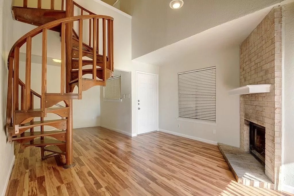 2500 Burleson Road, Unit 317 Austin, TX 78741 - Photo 6 of 12 an empty room with wooden floor and a fireplace
