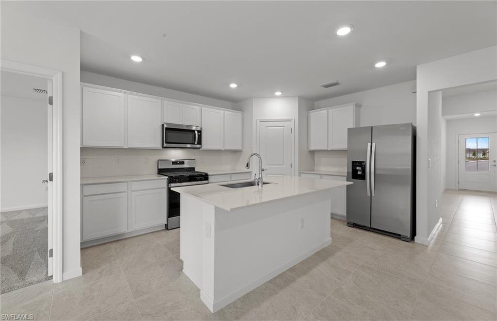 15893 Northridge Road Punta Gorda, FL 33982 - Photo 8 of 50 a kitchen with refrigerator a microwave a stove and cabinets