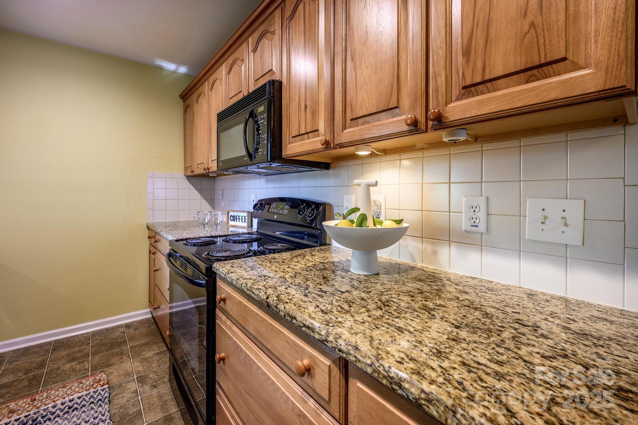 4314 Ivanhoe Place, Unit 26 Charlotte, NC 28205 - Photo 7 of 25 a kitchen with a stove and a microwave