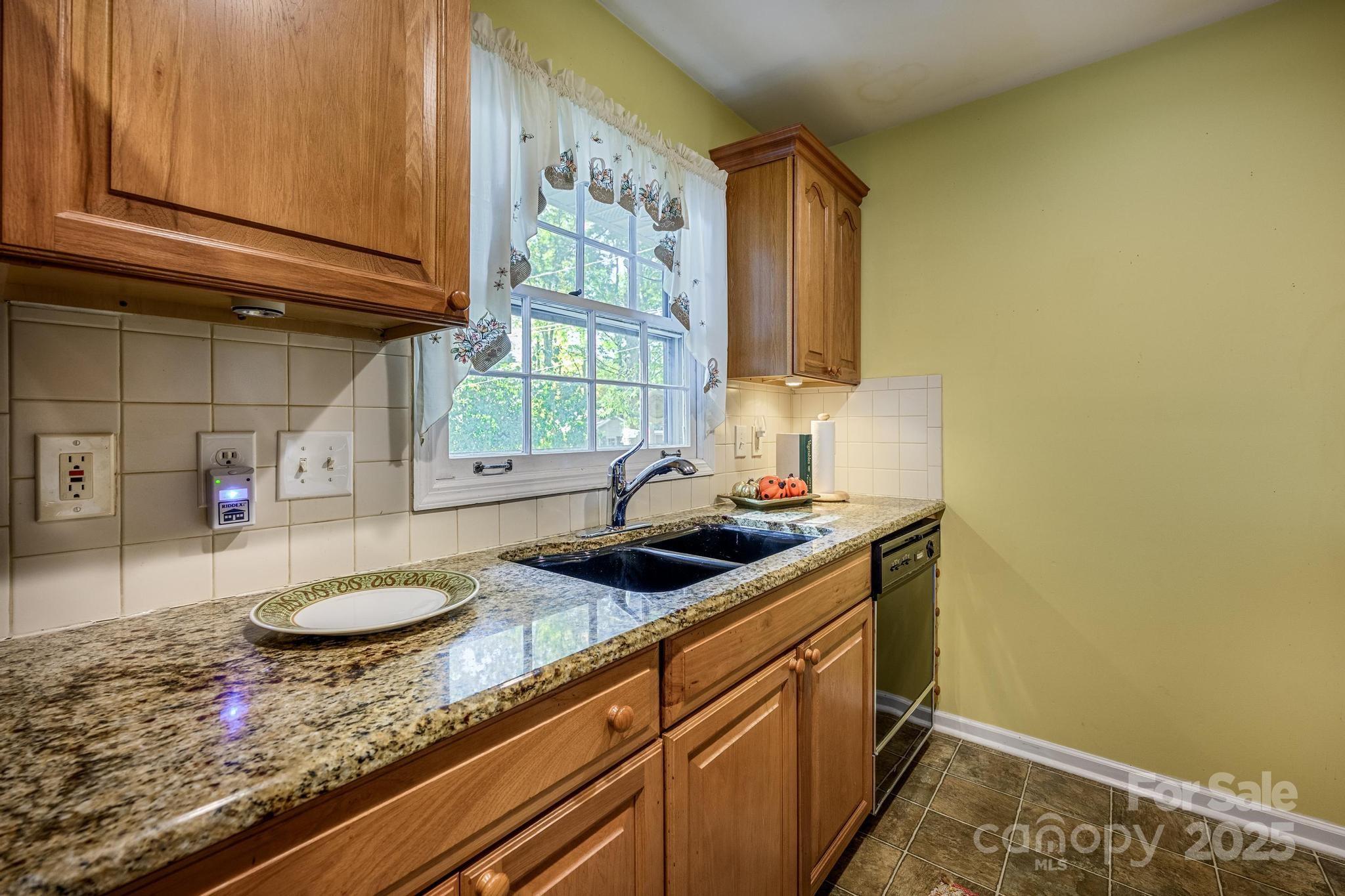 4314 Ivanhoe Place, Unit 26 Charlotte, NC 28205 - Photo 8 of 25 a kitchen with stainless steel appliances granite countertop a sink and a stove