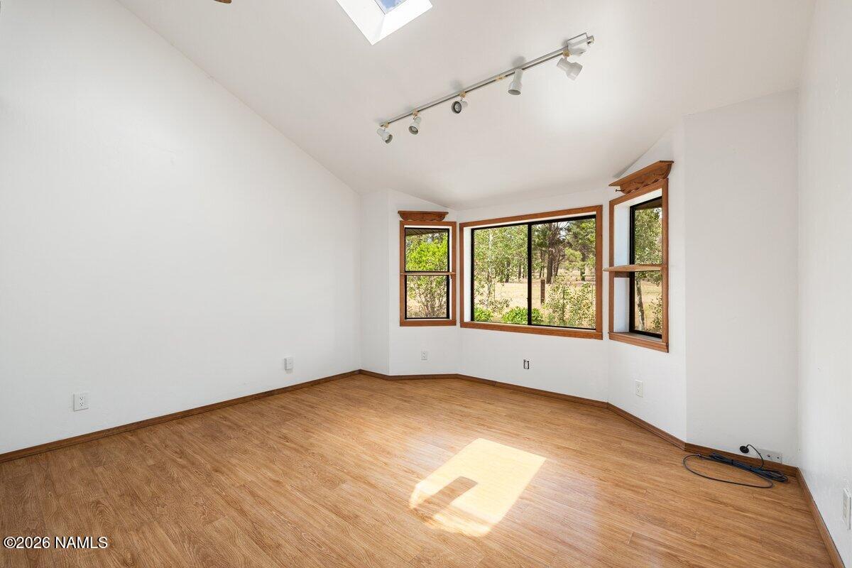 5535 East Western Star Road Flagstaff, AZ 86004 - Photo 15 of 49 an empty room with wooden floor and windows