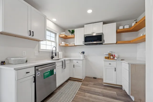 a view of a livingroom with wooden floor and a ceiling fan