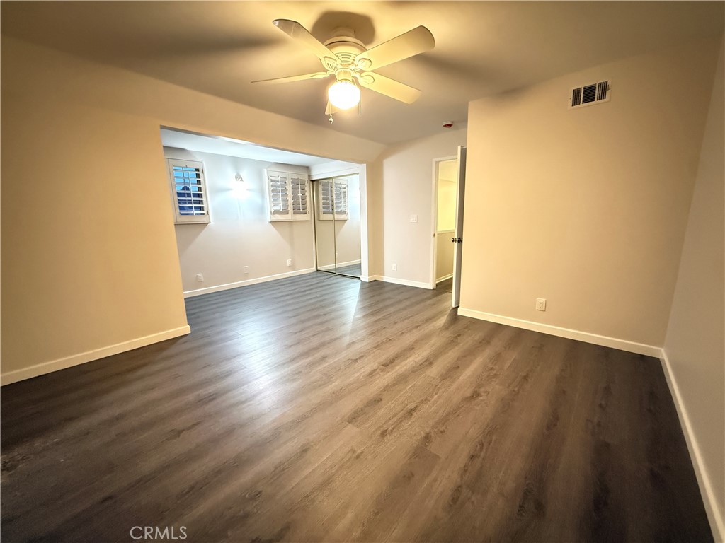 19312 Gunlock Avenue Carson, CA 90746 - Photo 26 of 44 an empty room with wooden floor chandelier fan and windows