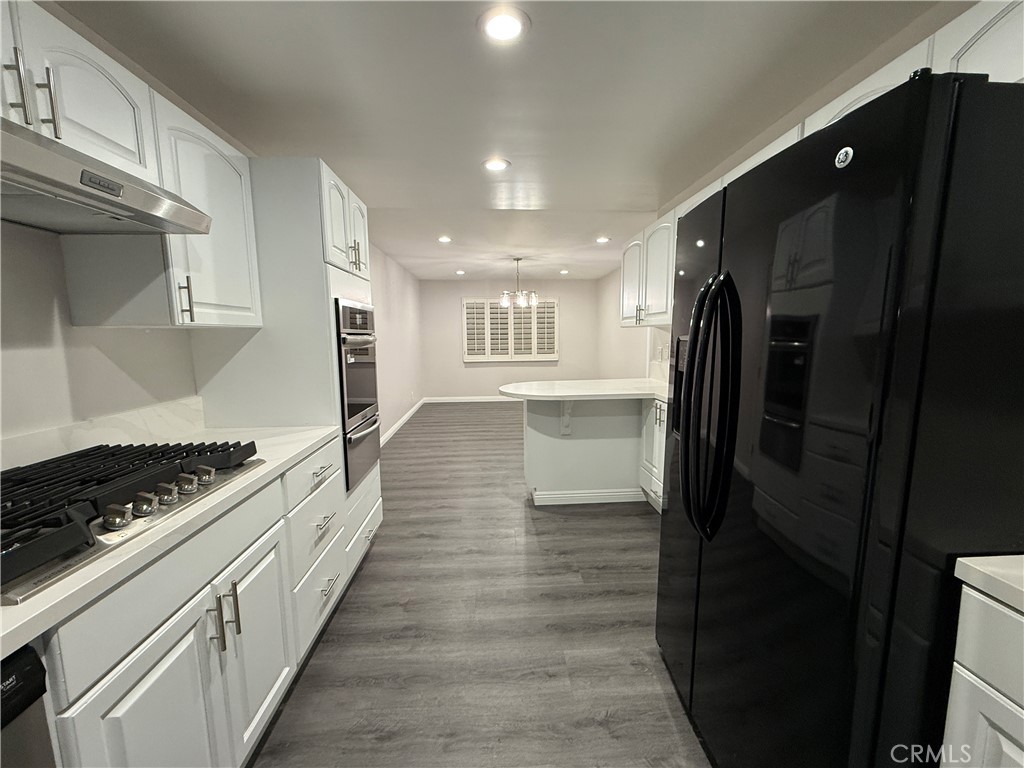 19312 Gunlock Avenue Carson, CA 90746 - Photo 6 of 44 a kitchen with stainless steel appliances a refrigerator a stove and wooden floor
