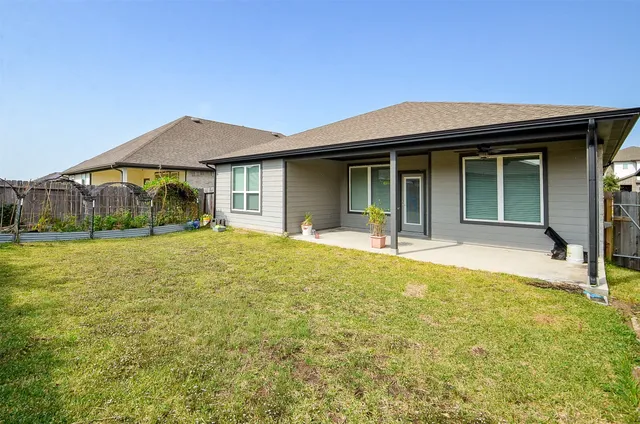 a view of a house with large windows and plants
