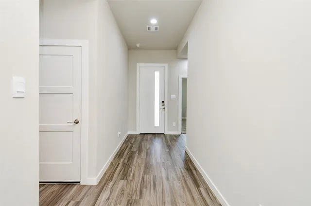 a view of a hallway with wooden floor