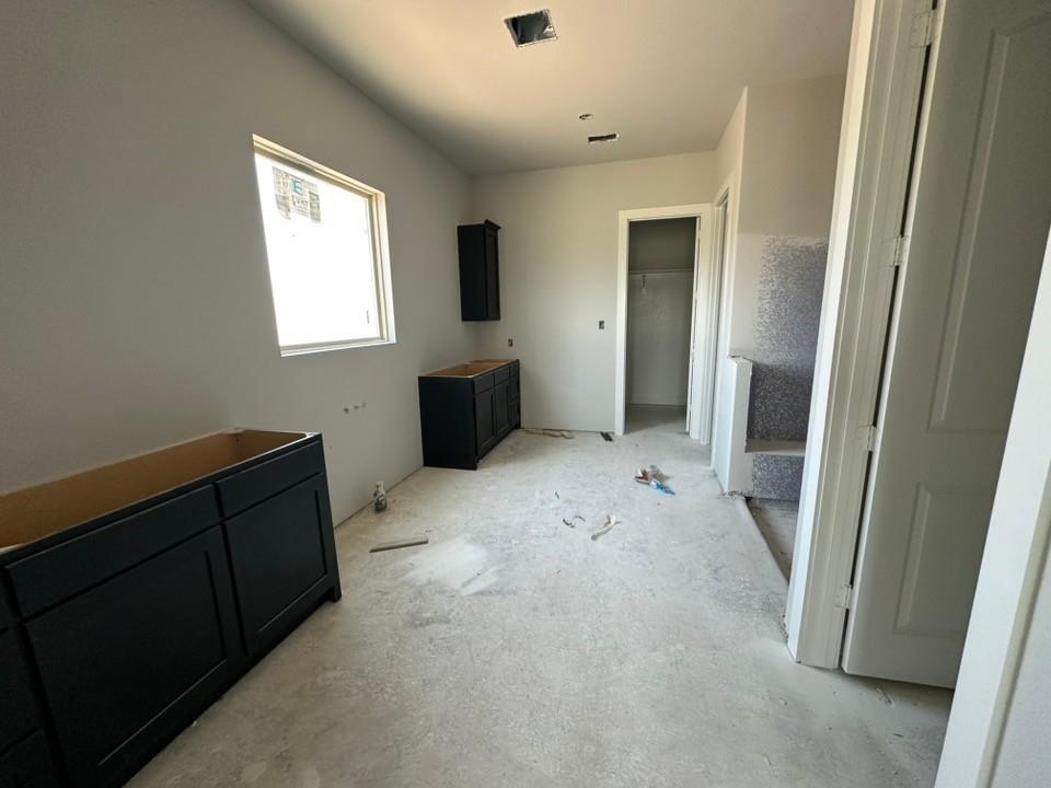 295 Brown Road Leonard, TX 75452 - Photo 12 of 26 Interior space featuring newly installed dark cabinetry, a large window providing natural light, and a partially finished staircase