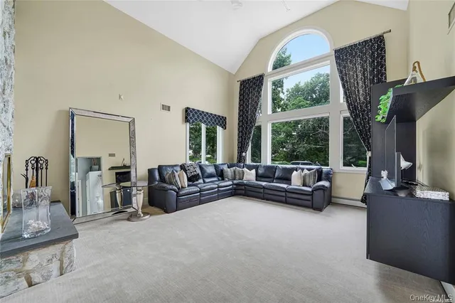 a living room with furniture a large window wooden floor and a chandelier