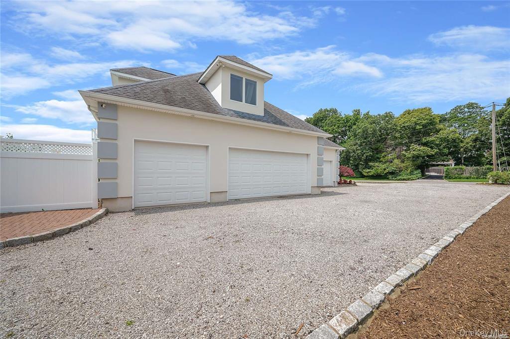4 Mill Pond Road Hampton Bays, NY 11946 - Photo 19 of 24 a front view of a house with a yard and garage