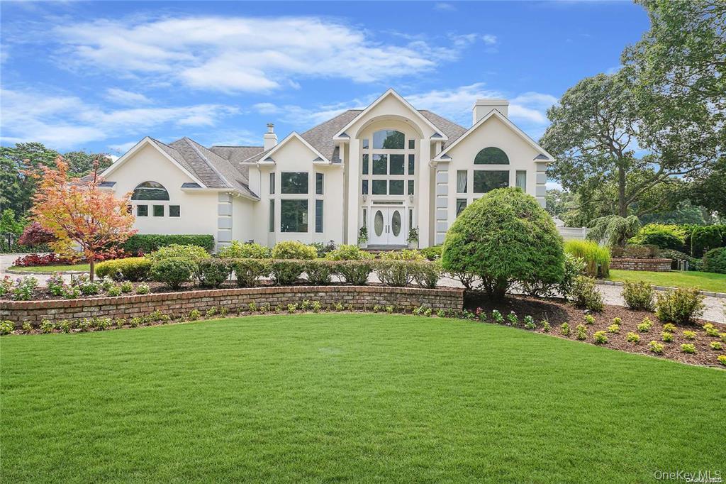 4 Mill Pond Road Hampton Bays, NY 11946 - Photo 20 of 24 a front view of a house with a garden