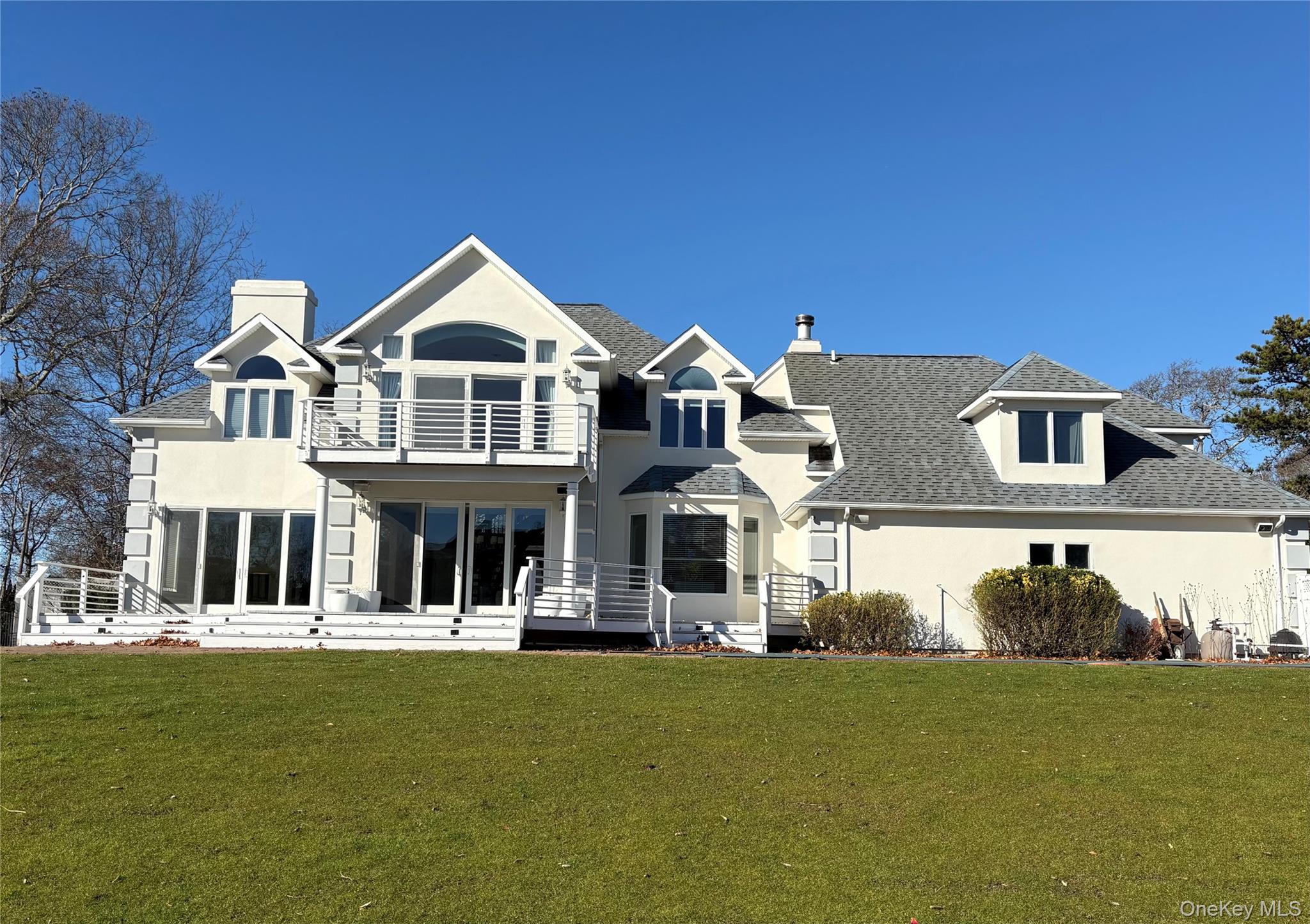 4 Mill Pond Road Hampton Bays, NY 11946 - Photo 5 of 24 a front view of a house with a yard