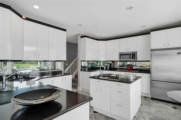 a kitchen with stainless steel appliances a stove a sink and a refrigerator