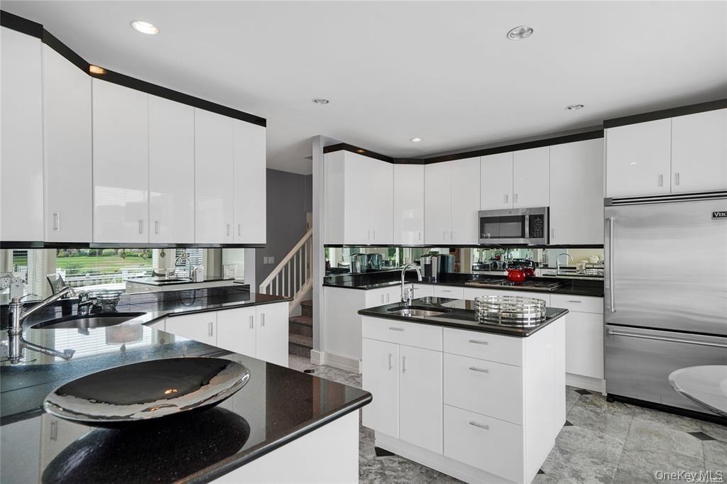 4 Mill Pond Road Hampton Bays, NY 11946 - Photo 10 of 24 a kitchen with stainless steel appliances a stove a sink and a refrigerator