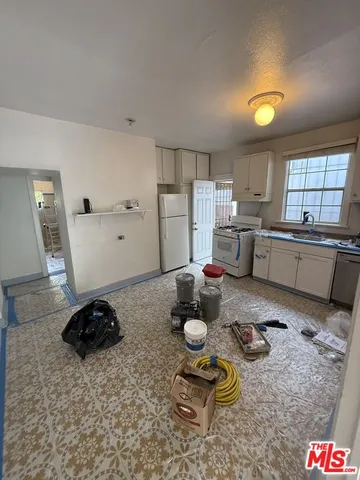 a kitchen with a refrigerator and a stove top oven