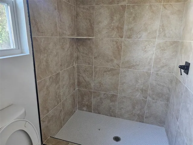 a bathroom with a granite countertop sink vanity and toilet
