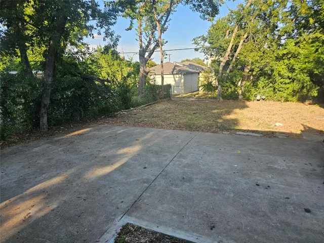 a backyard of a house with barbeque oven table and chairs