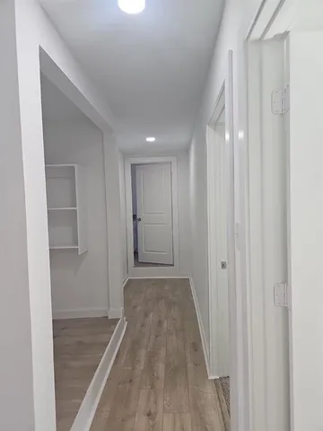 a view of a hallway with wooden floor