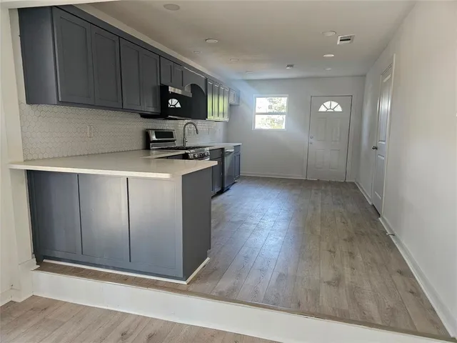 a kitchen with stainless steel appliances a refrigerator sink and microwave