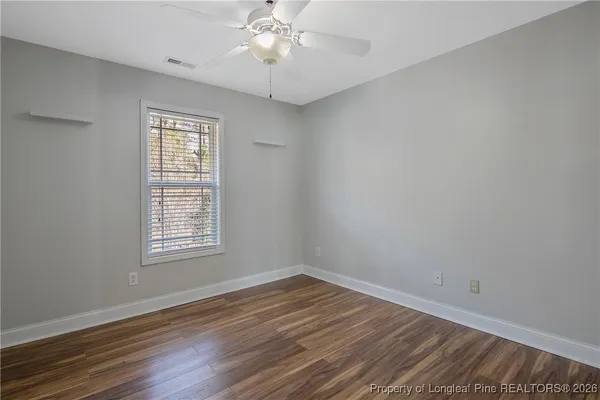a view of an empty room with wooden floor