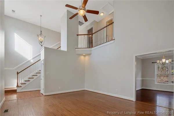 a view of a dining room with furniture a chandelier and wooden floor