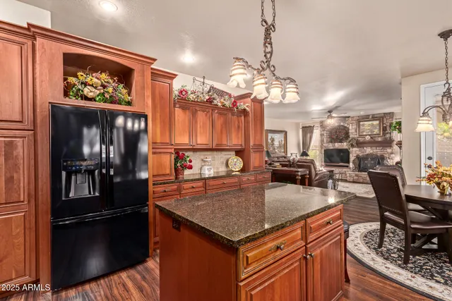 a kitchen with stainless steel appliances granite countertop a sink refrigerator and cabinets