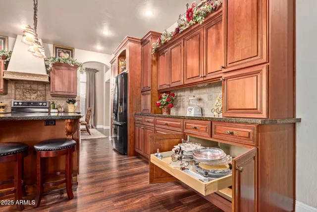 a kitchen with stainless steel appliances granite countertop a refrigerator a stove and a wooden cabinets