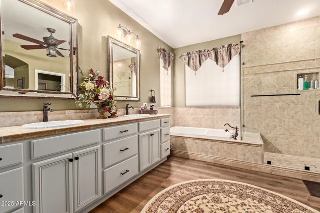 a spacious bathroom with double vanity a mirror a bathtub and a shower
