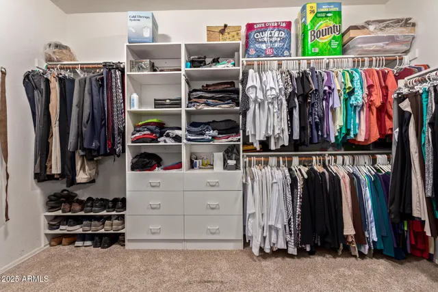 a view of walk in closet with clothes and shoes