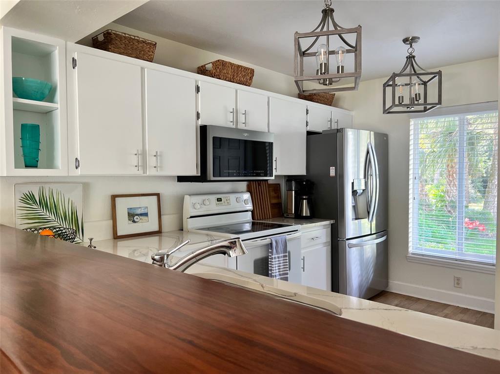 12595 Southeast Sunset Harbor Road Weirsdale, FL 32195 - Photo 18 of 25 a view of a kitchen with stainless steel appliances wooden floor and a window