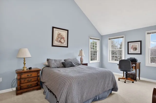 a bedroom with a bed and a dresser next to a window