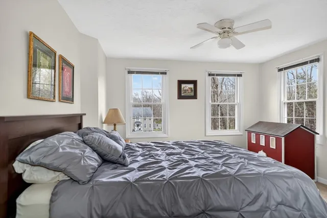 a bedroom with a bed next to a window with a bookshelf