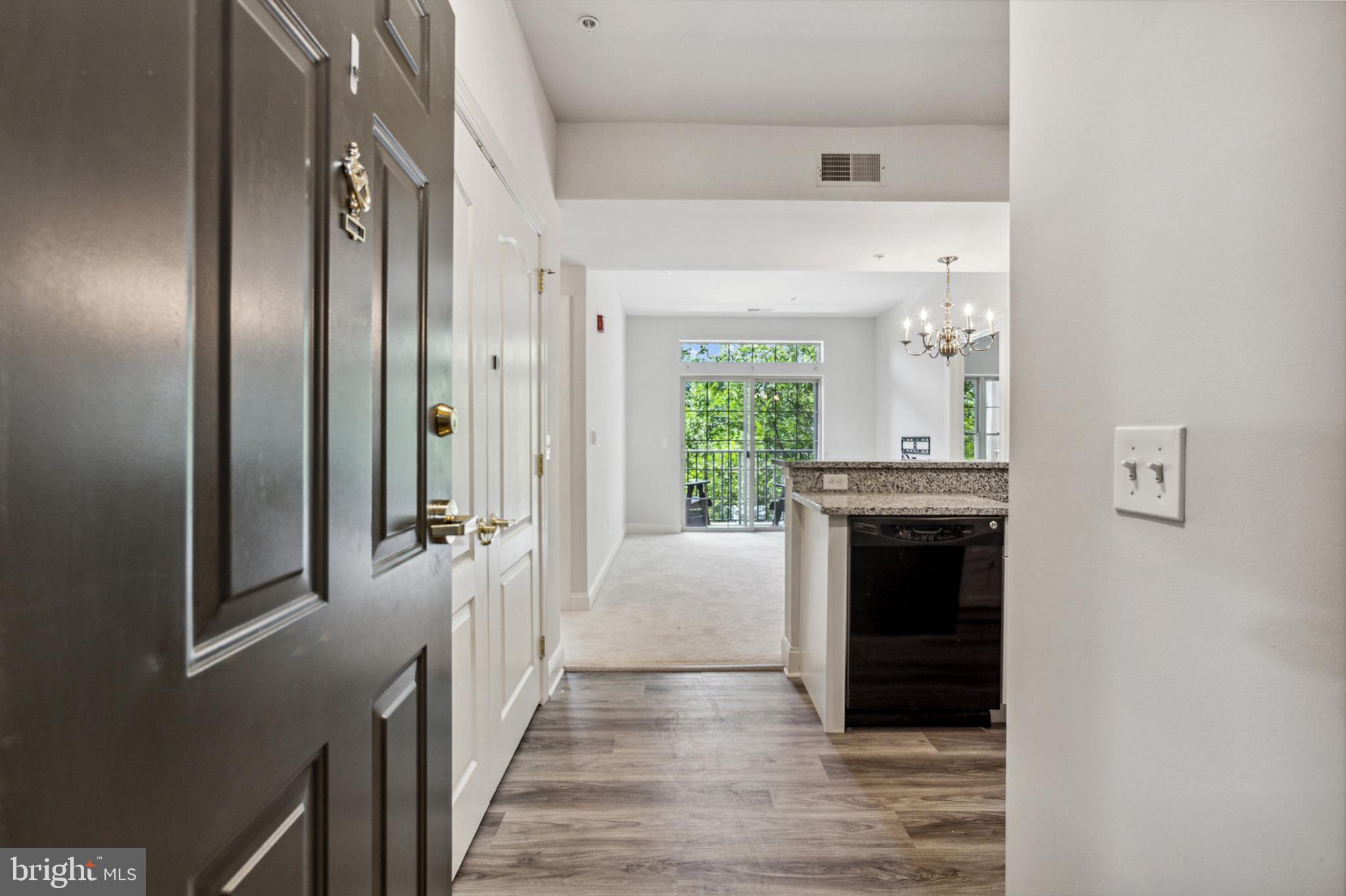 3000 Fountainview Circle, Unit 3311 Newark, DE 19713 - Photo 10 of 32 a view of a hallway with wooden floor and a kitchen