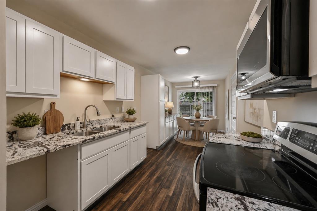 7318 Emory Oak Lane Dallas, TX 75249 - Photo 4 of 28 Kitchen featuring white shaker-style cabinetry, a stainless steel sink with a gooseneck faucet, light-toned granite countertops, and wood-finish flooring
