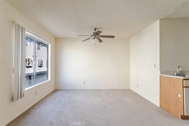 an empty room with a ceiling fan and a window