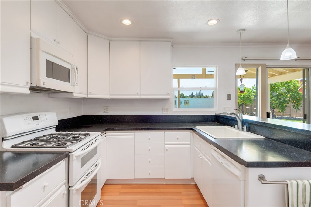 9130 Duncan Avenue Riverside, CA 92503 - Photo 10 of 34 a kitchen with granite countertop a sink a window and stainless steel appliances