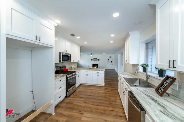 a kitchen with white cabinets and counter