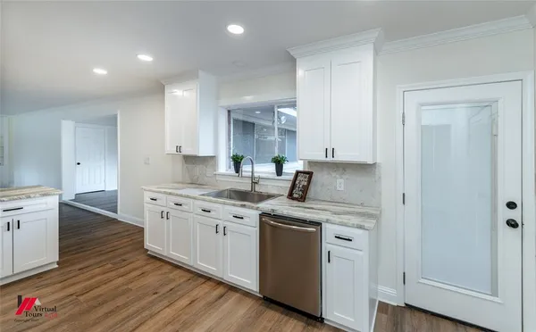 a kitchen with stainless steel appliances granite countertop a sink stove and wooden floor