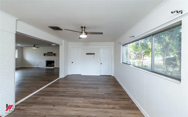 a view of a hallway with wooden floor and a cabinet