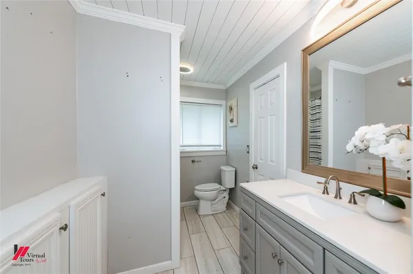 a bathroom with a granite countertop sink mirror and toilet